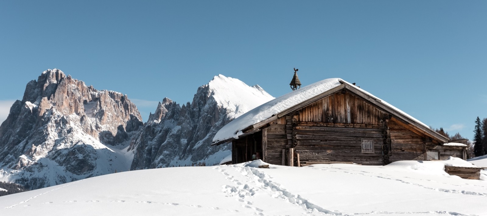 Chalet enneigé devant la montagne